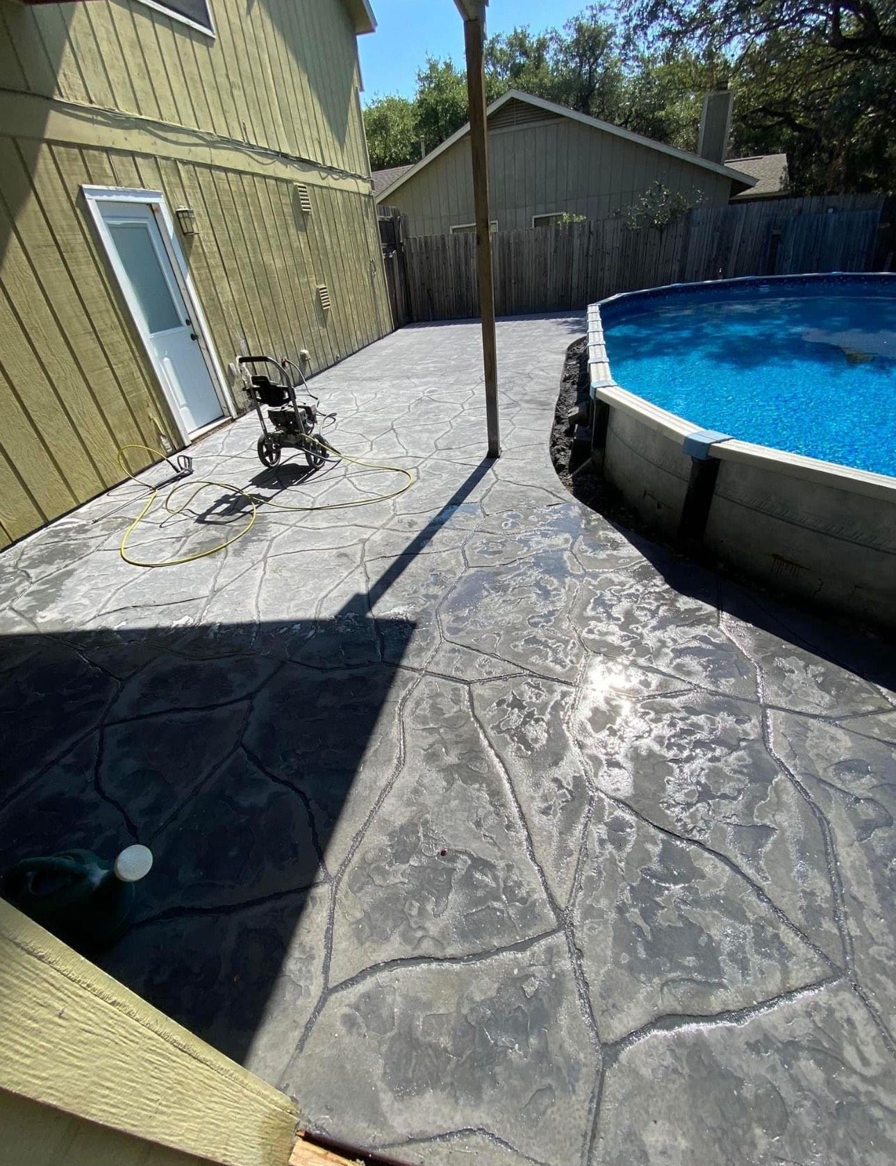 There is a swimming pool in the backyard of a house.