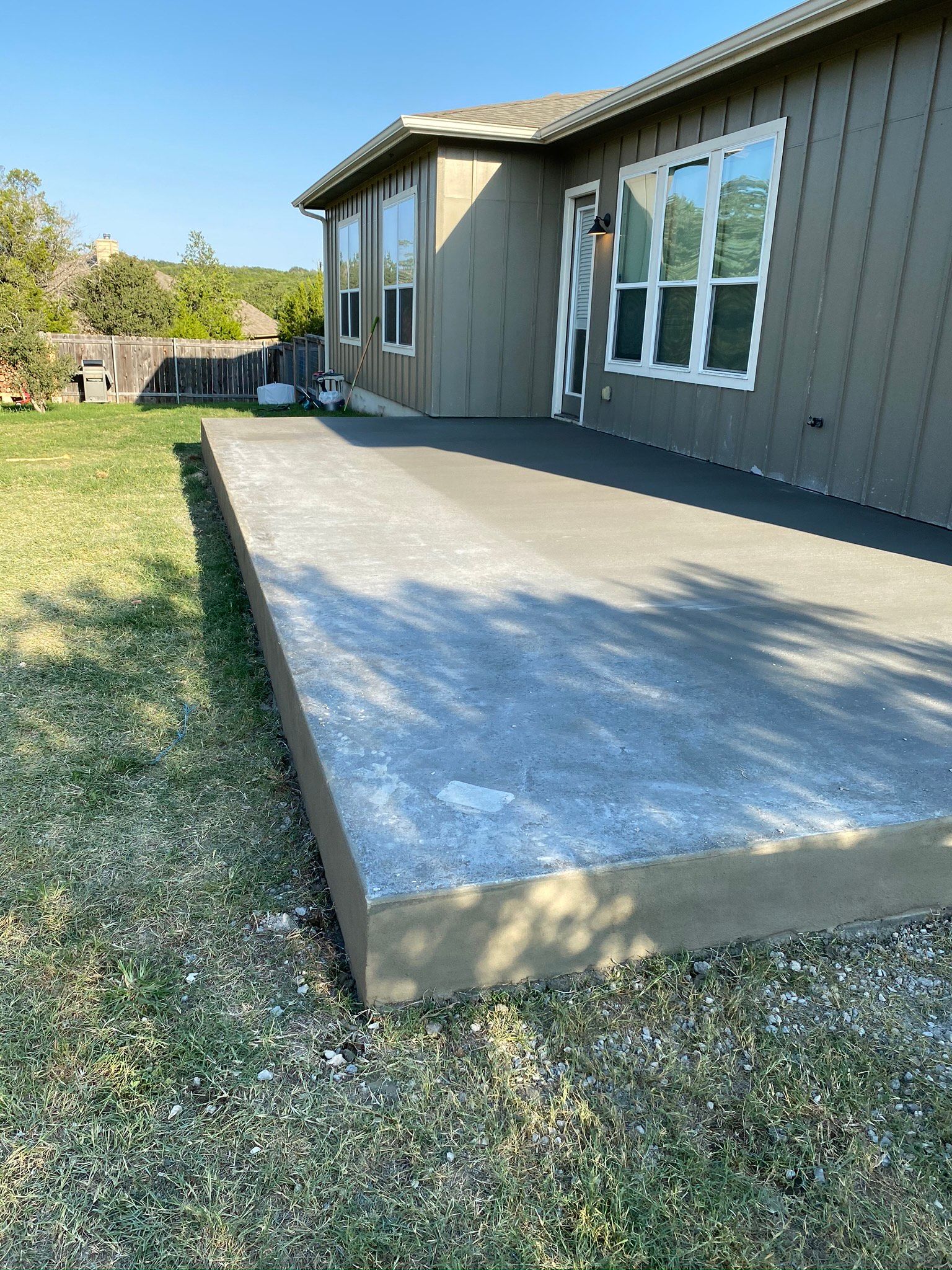 A concrete deck is being built in front of a house.