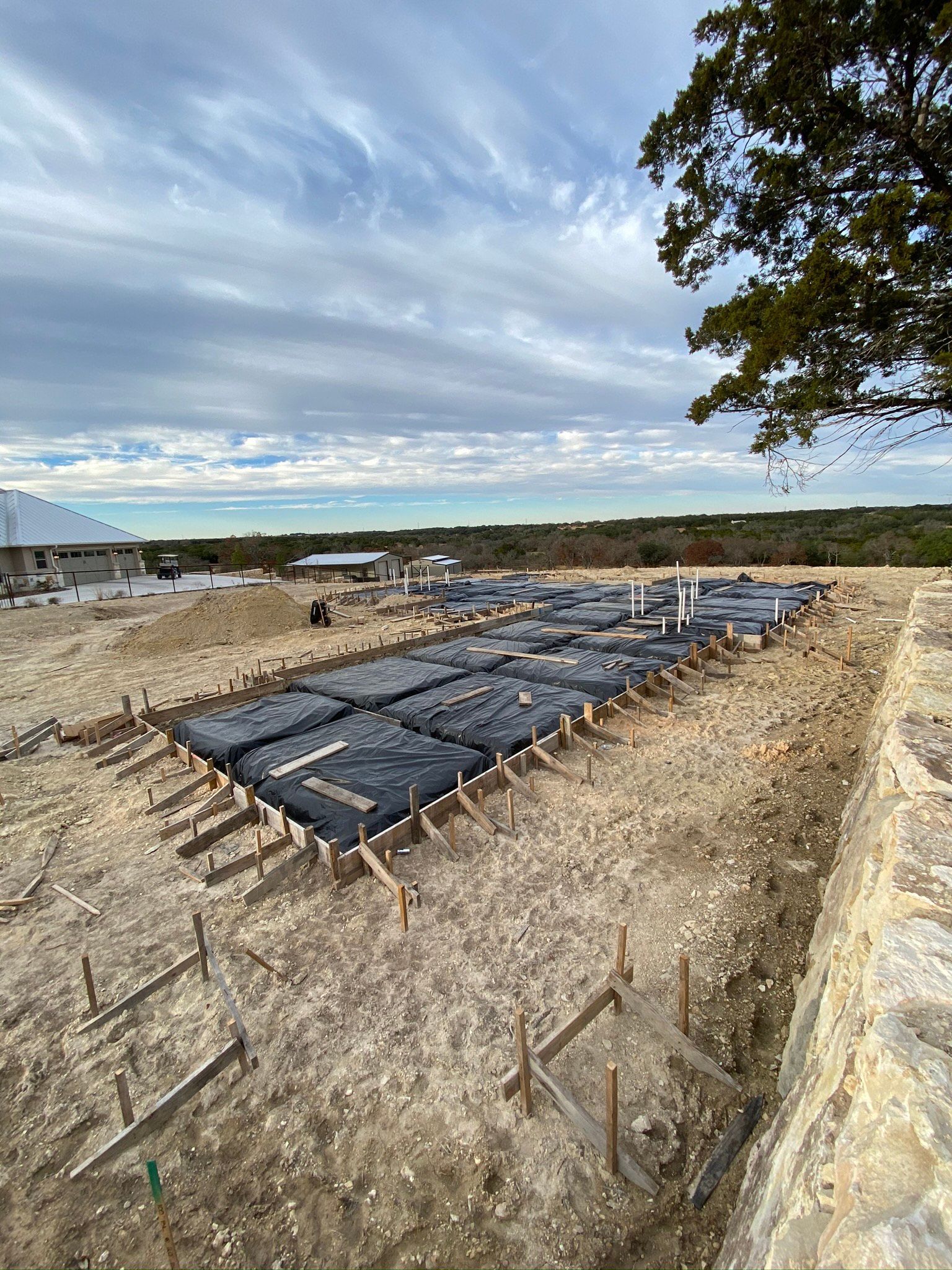 A large concrete slab is sitting on top of a dirt field.