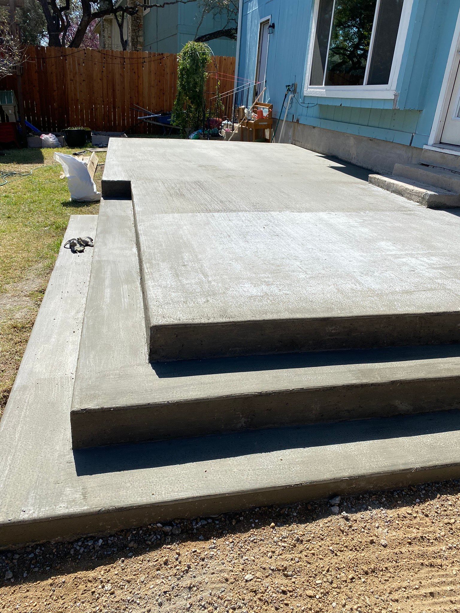 A concrete walkway with stairs leading up to a house.