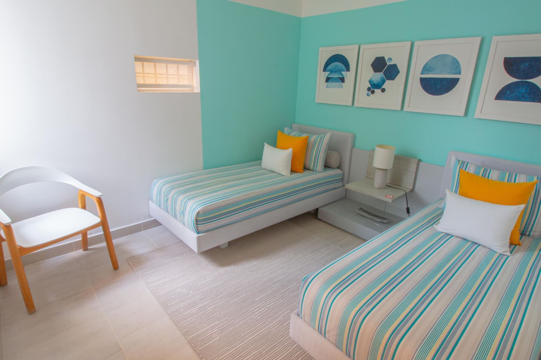 Un dormitorio con dos camas individuales y un sillón.