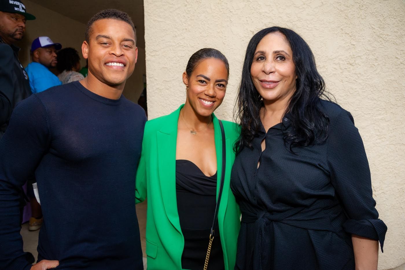 A man and two women are posing for a picture together.