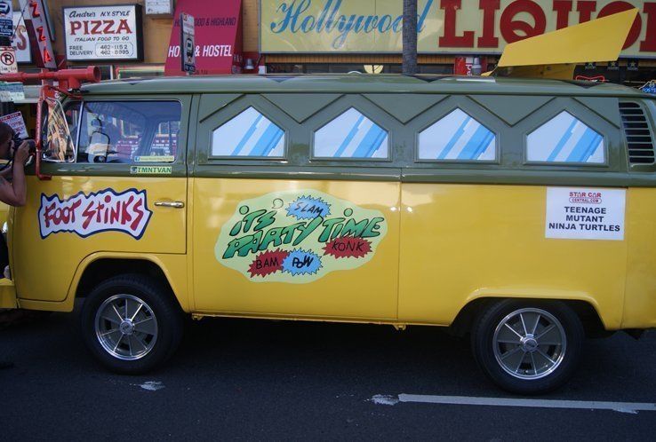 Teenage Mutant Ninja Turtles party van, yellow and green, parked on the street.