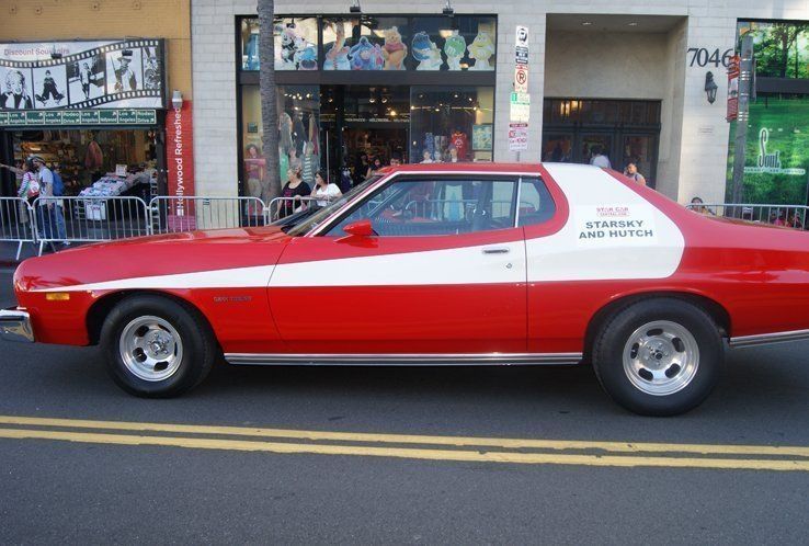 Red and white vintage car parked on the street with 