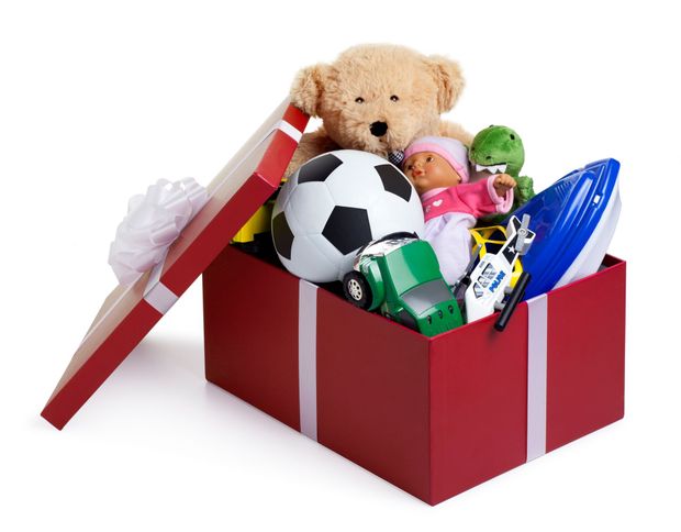 Red gift box overflowing with toys: teddy bear, soccer ball, doll, car, and more.