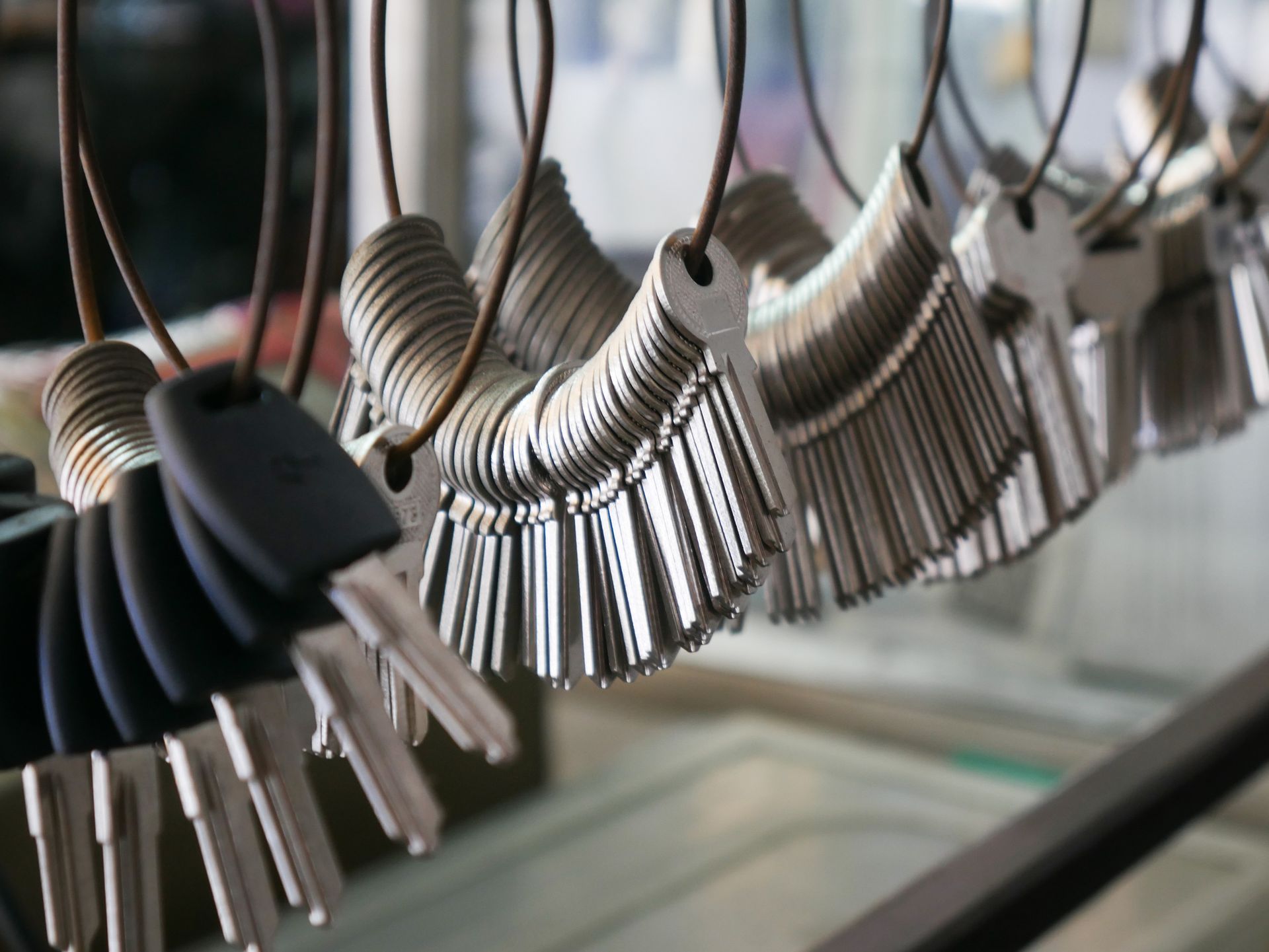 Keys hanging in rows, organized on rings, at a locksmith shop.