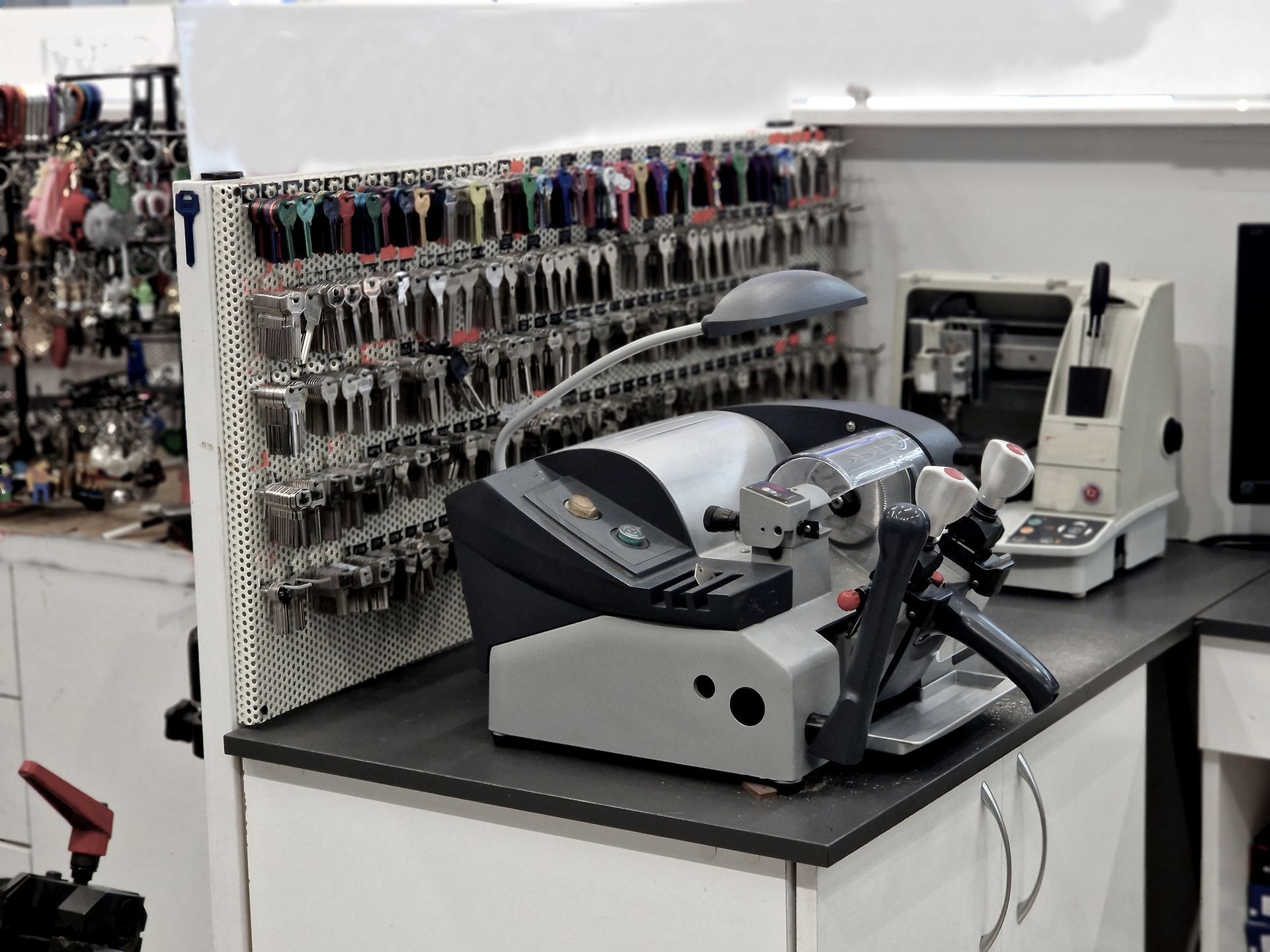 Key-cutting machine with keys on display in a locksmith shop.