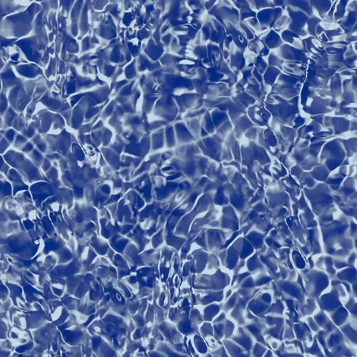 Blue water surface with rippling light reflections.