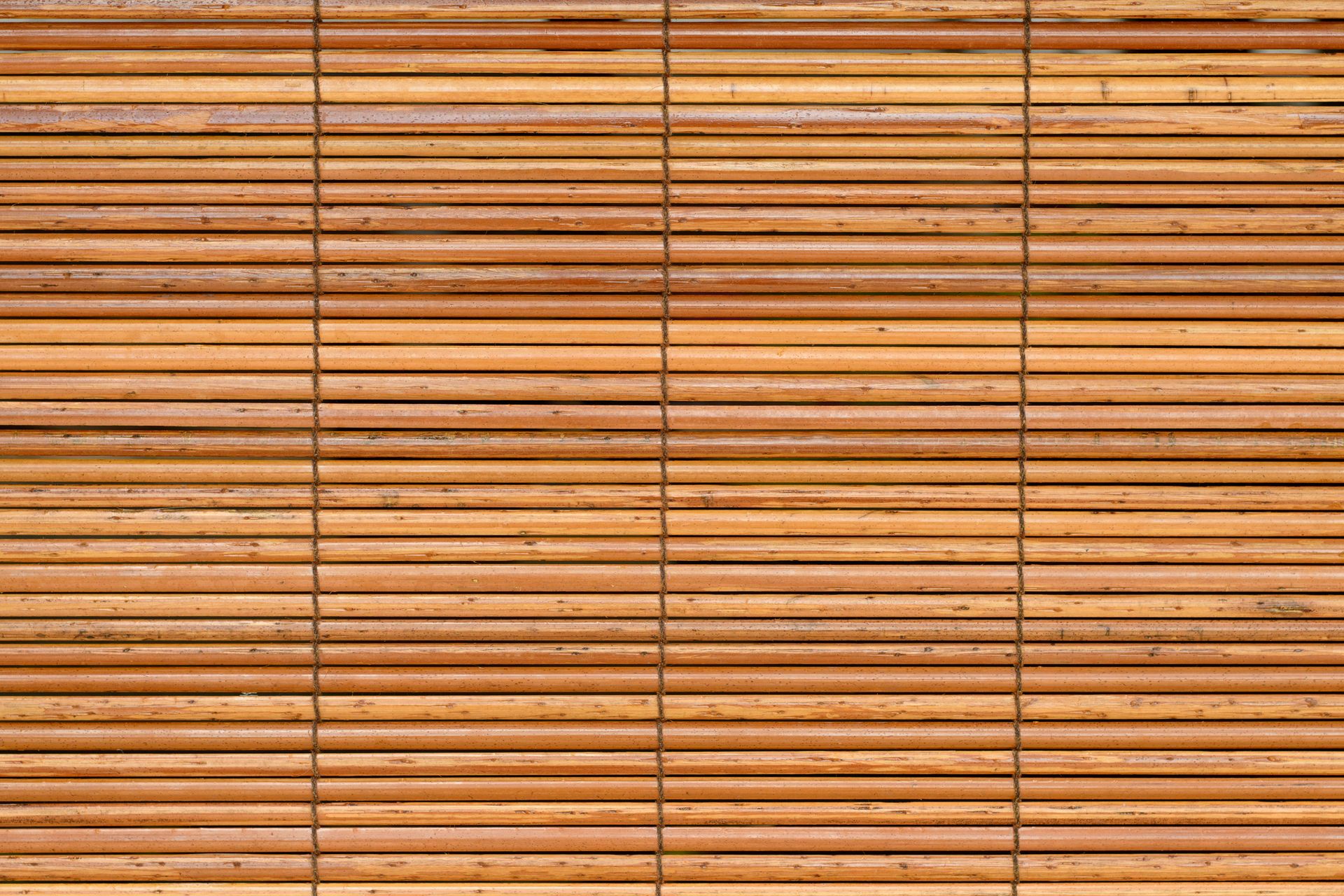 A close up of a bamboo blind on a window.