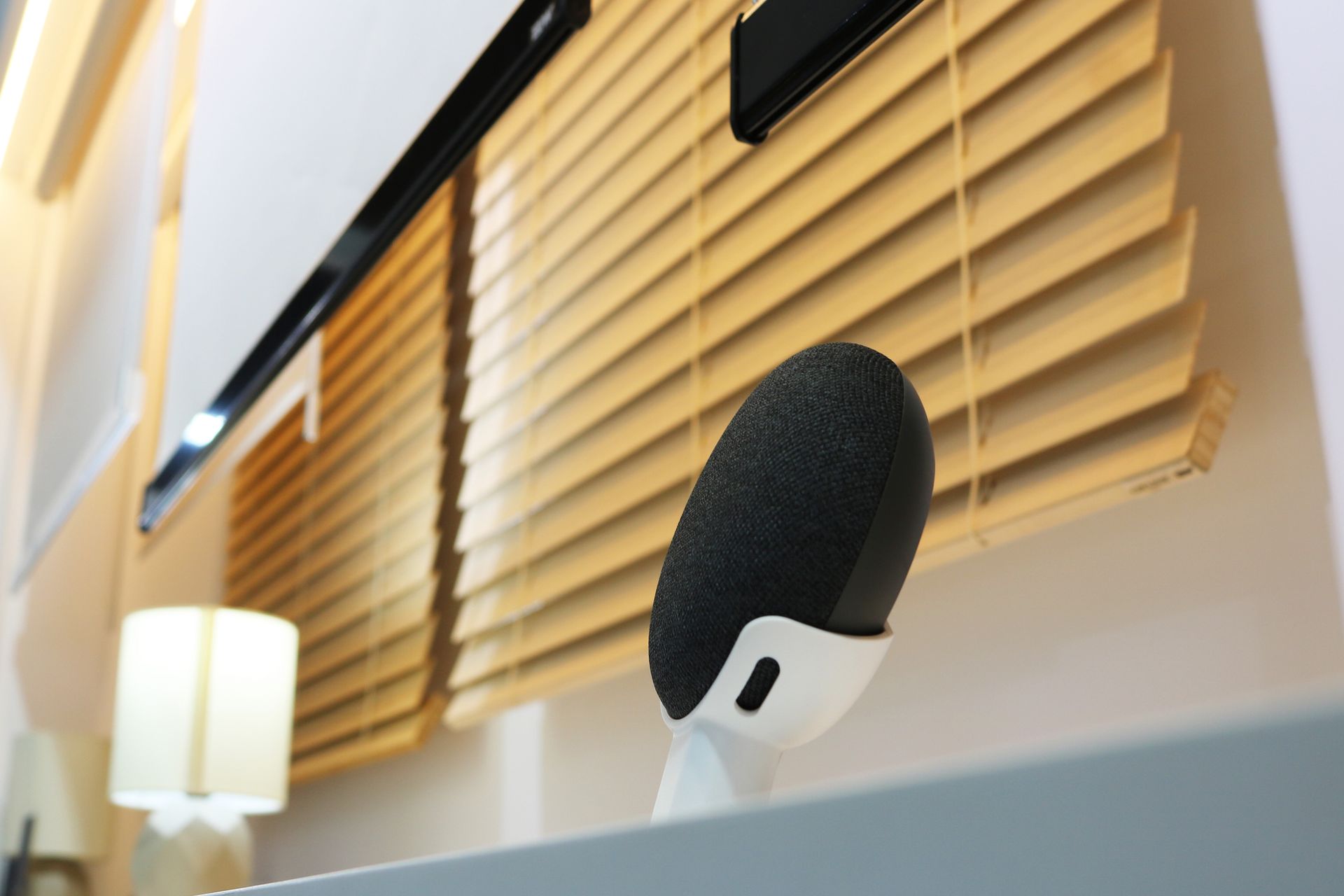 A microphone is sitting in front of a window with blinds