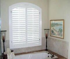 A white window with black shutters on a house