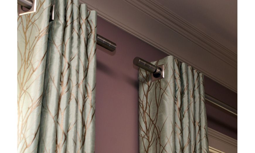 A close up of a row of shower curtains with metal hooks.