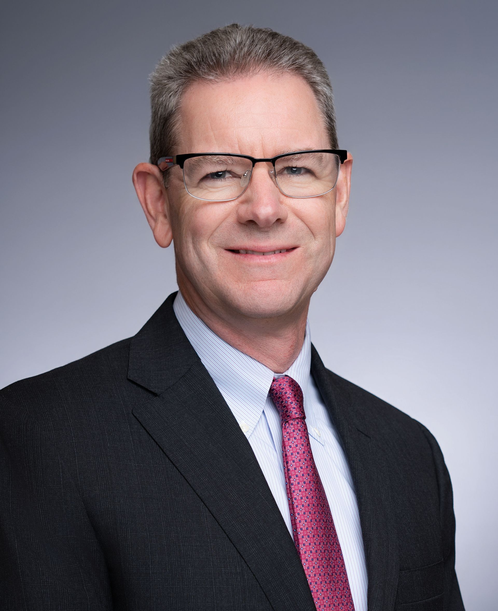 A man in a suit and tie is smiling for the camera.