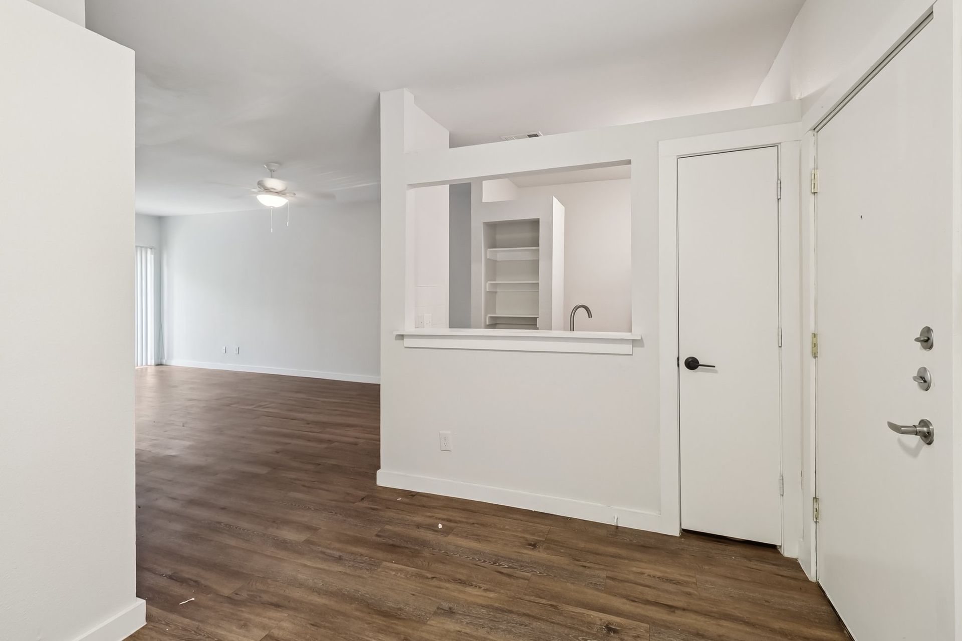 Photo of a living room entrance and the kitchen next to it