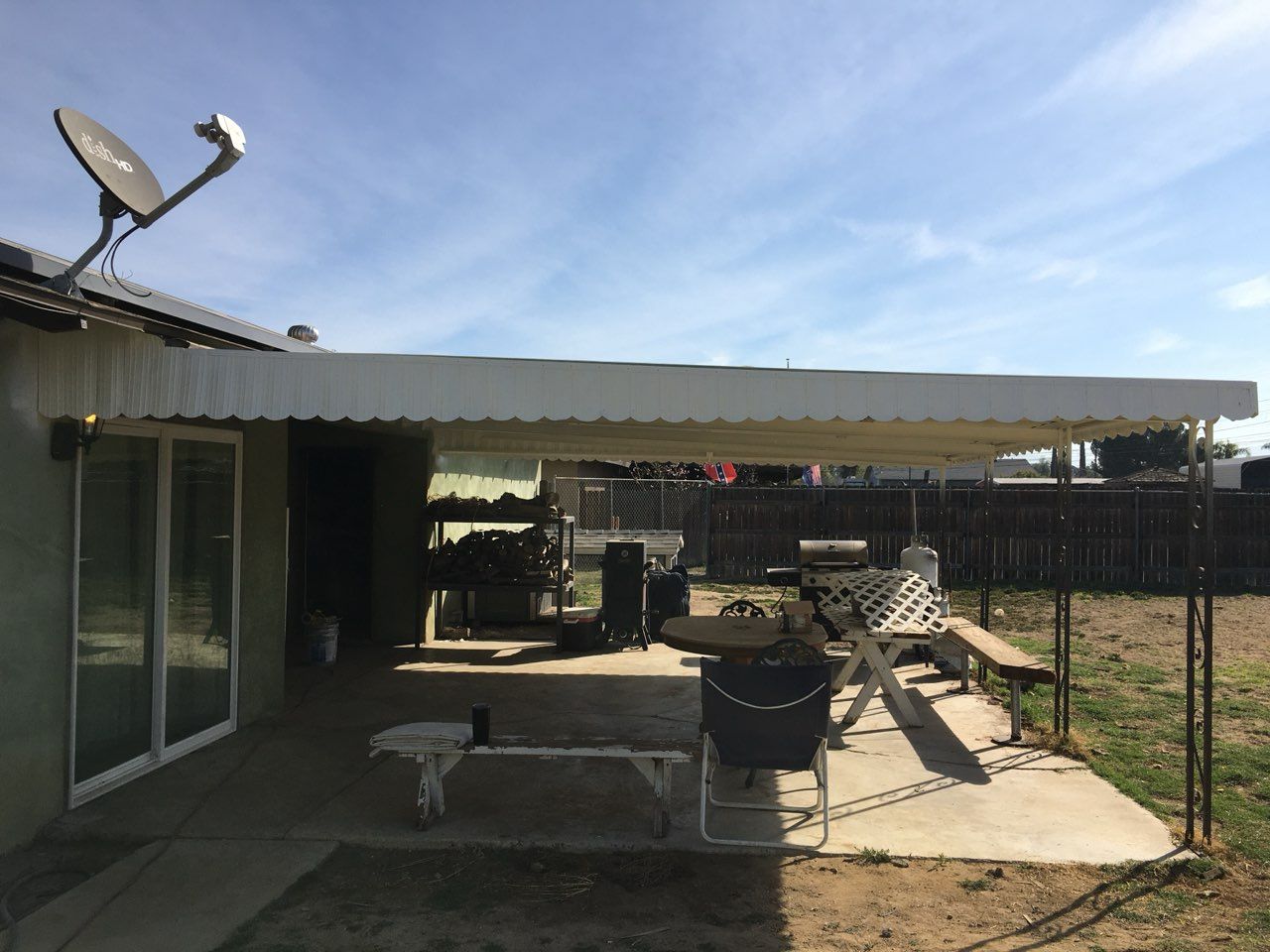 Patio with a metal roof, outdoor furniture, and a satellite dish.