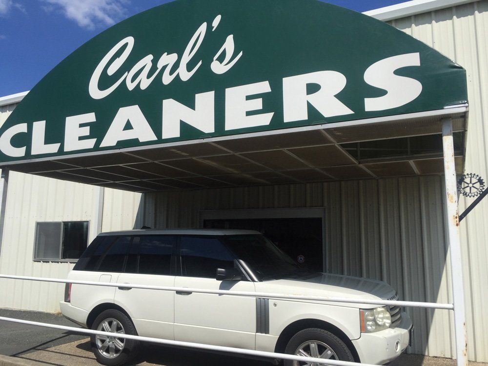 A car is parked in front of carl 's cleaners