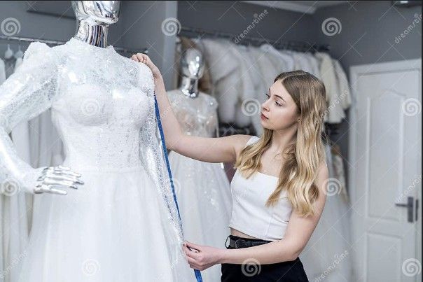 Woman tailor measuring a wedding dress