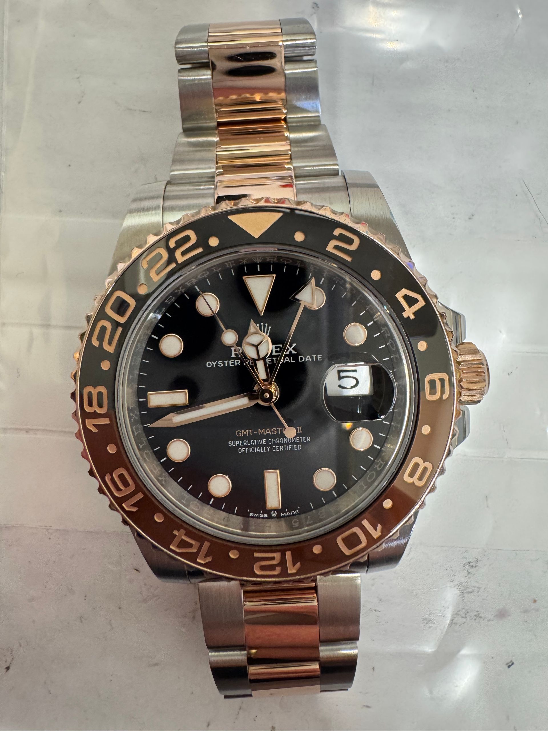 Een tweekleurig Rolex GMT-Master II roestvrij staal en roségoud met een zwarte wijzerplaat en een bruin-zwarte lunette.