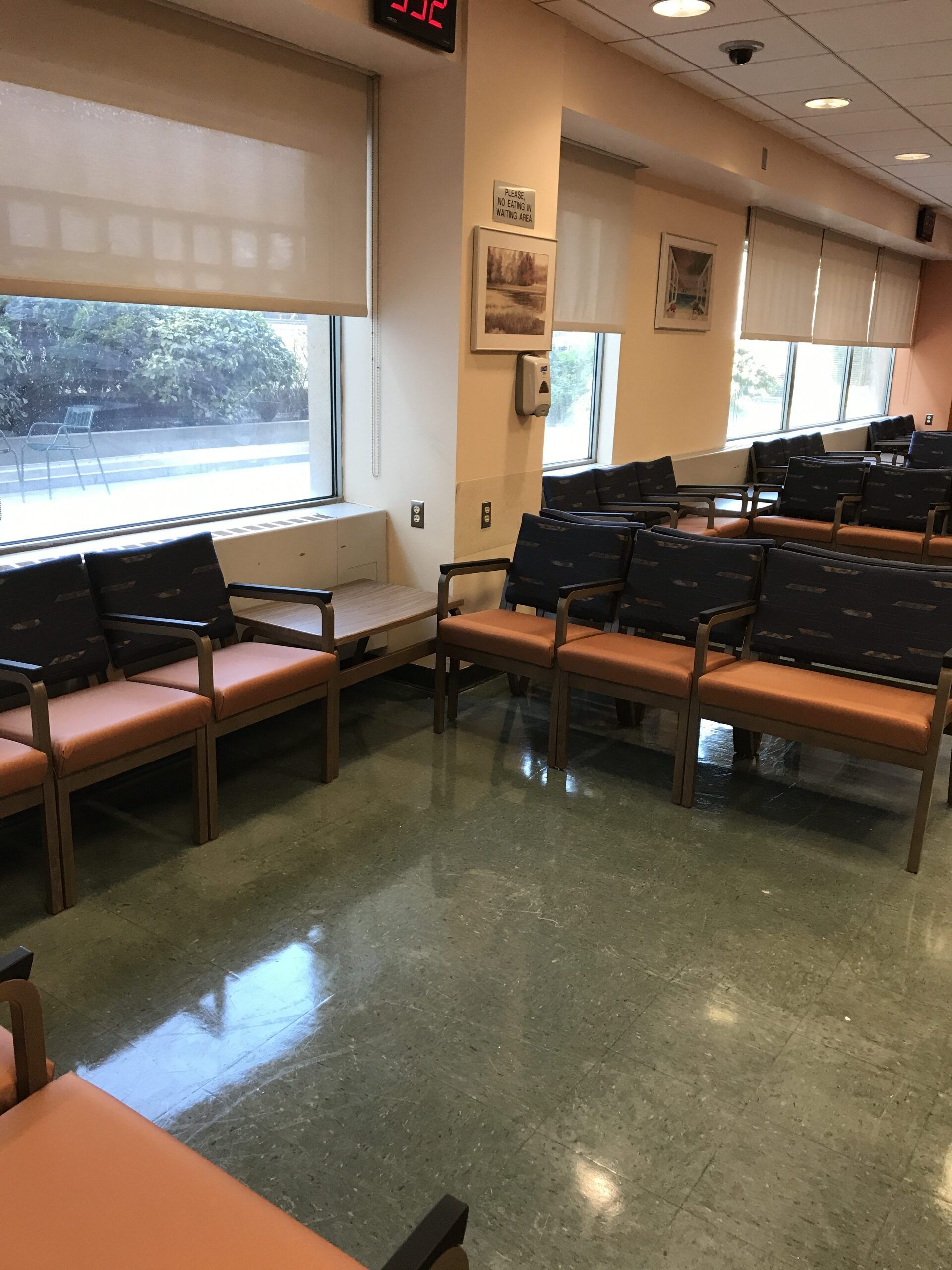 A waiting room with chairs and a clock that says 3:22