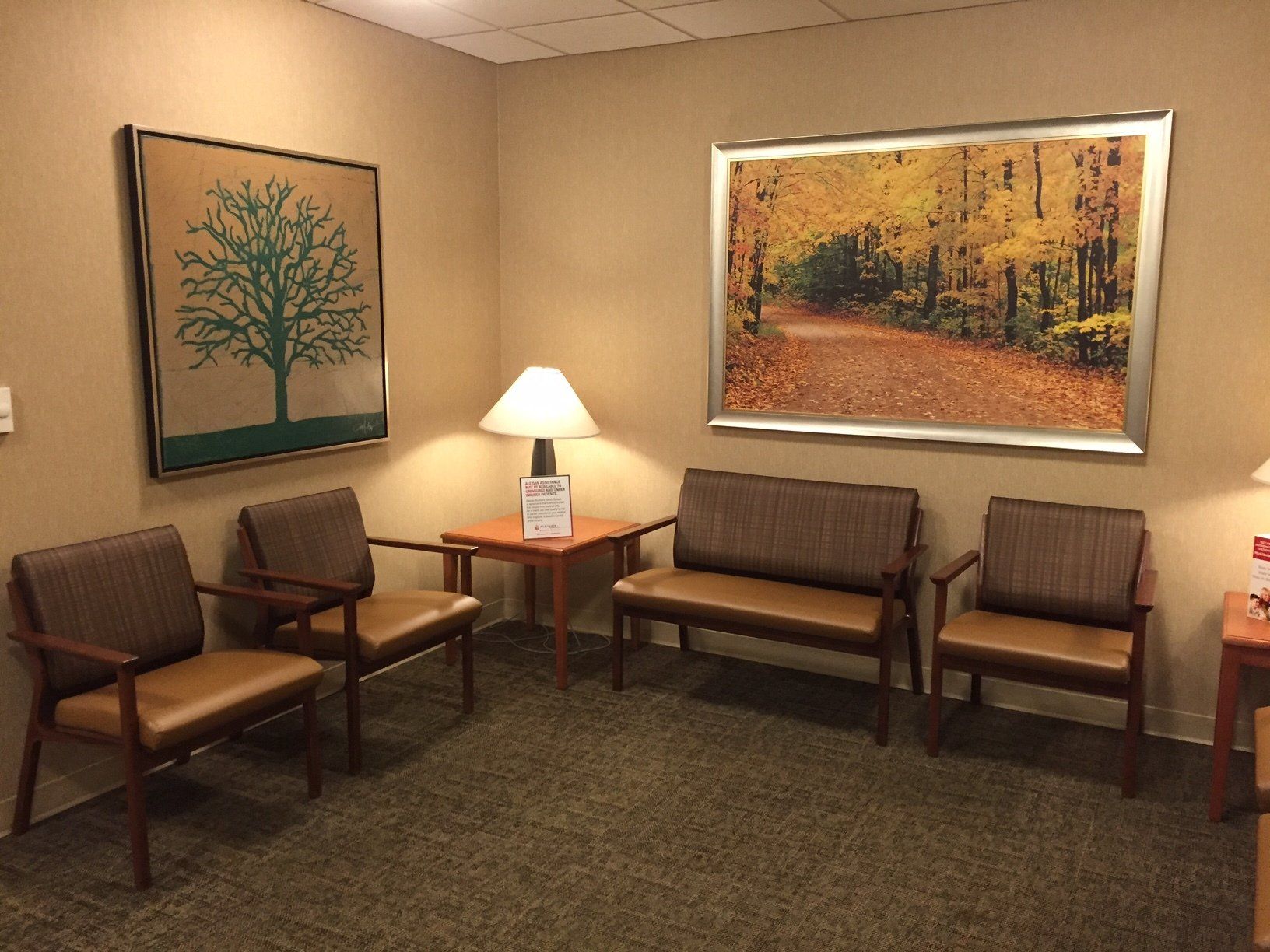 A waiting room with a picture of a tree on the wall