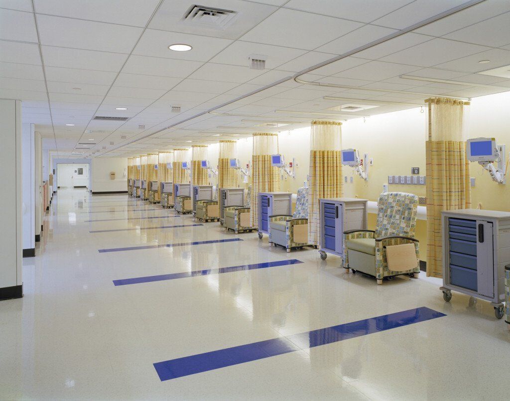 A hospital hallway with a row of chairs and carts