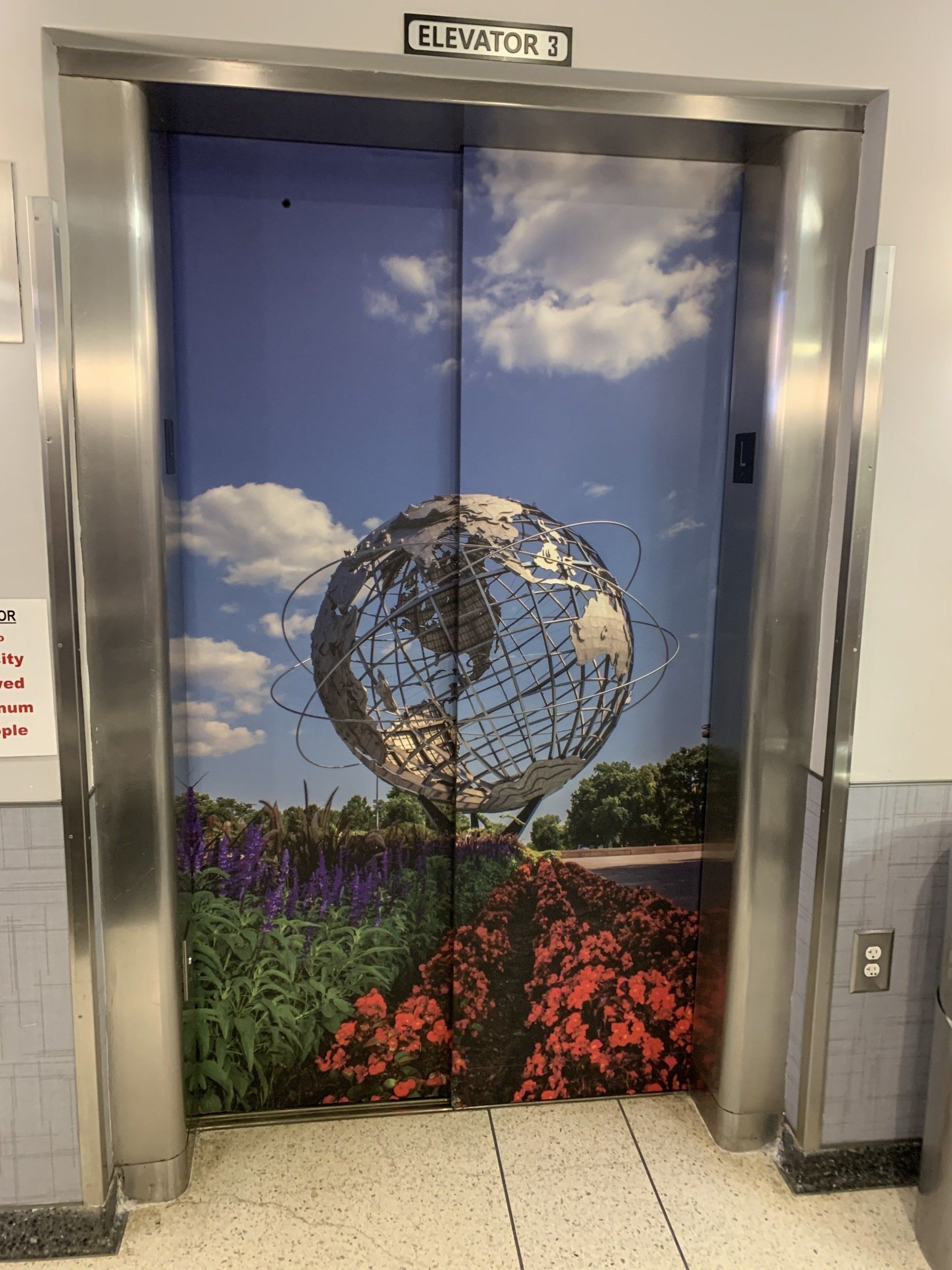 An elevator with a picture of a globe on the door