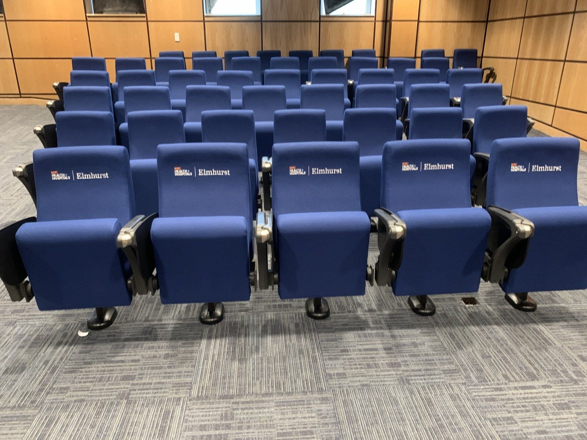 Rows of blue chairs in a room with a carpet