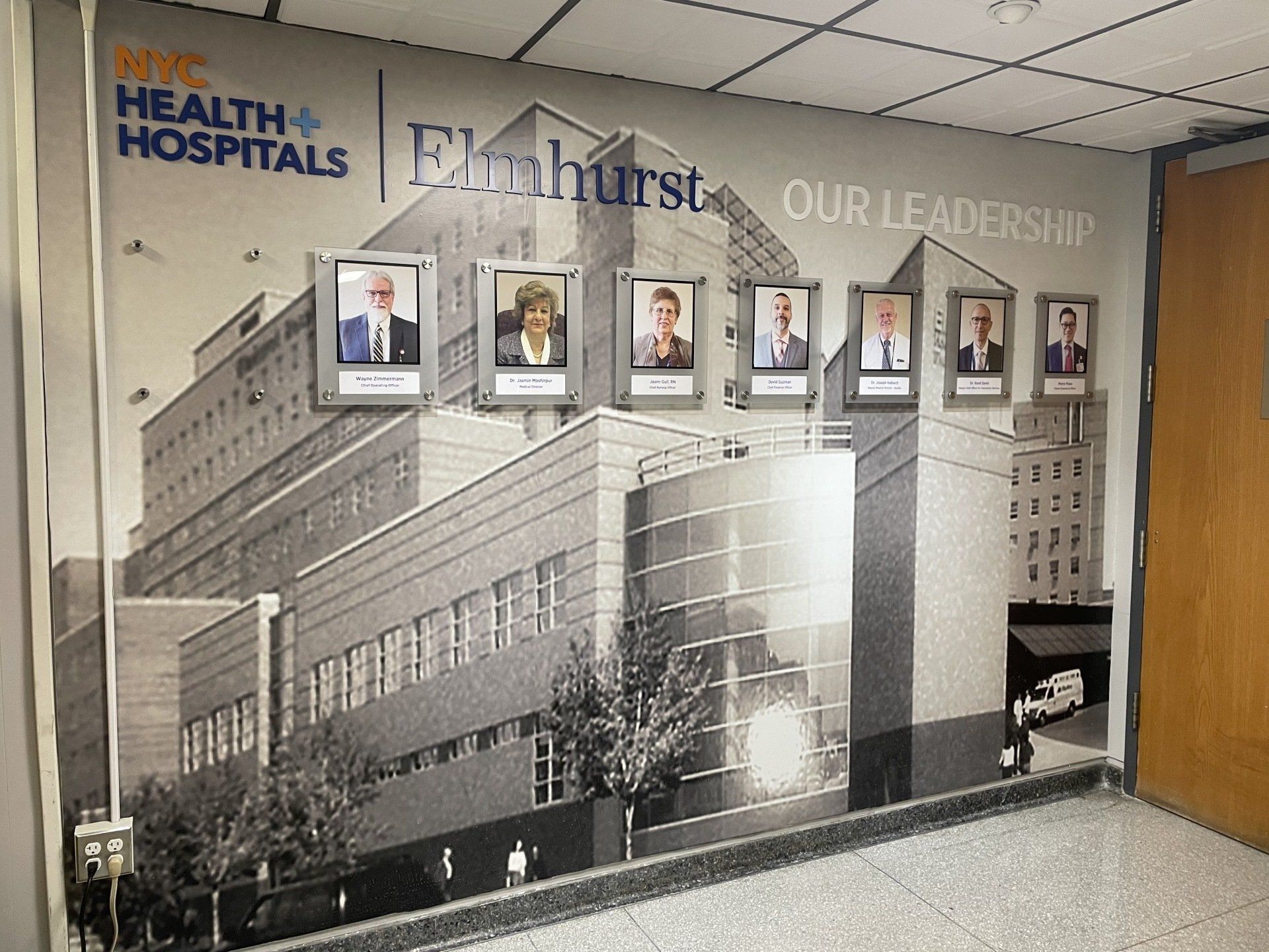A wall with a picture of a building and a sign that says health & hospitals