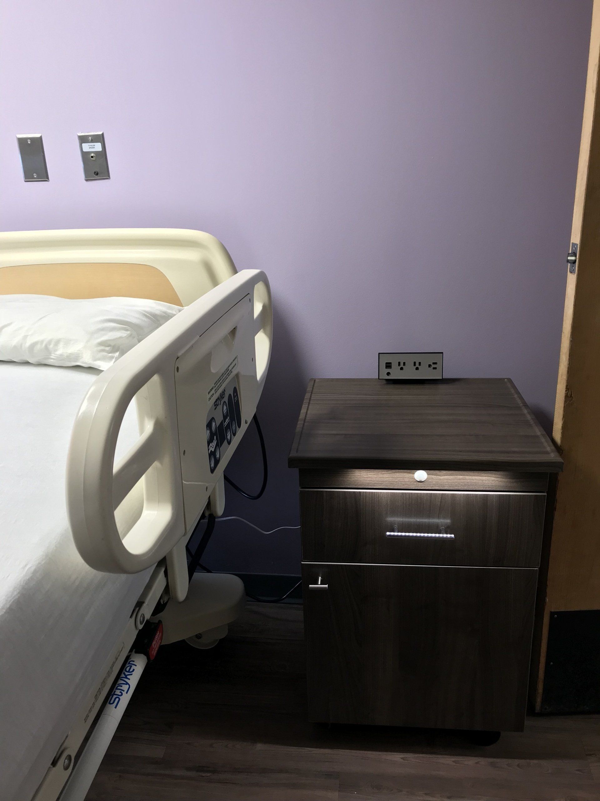 A hospital bed in a room with purple walls