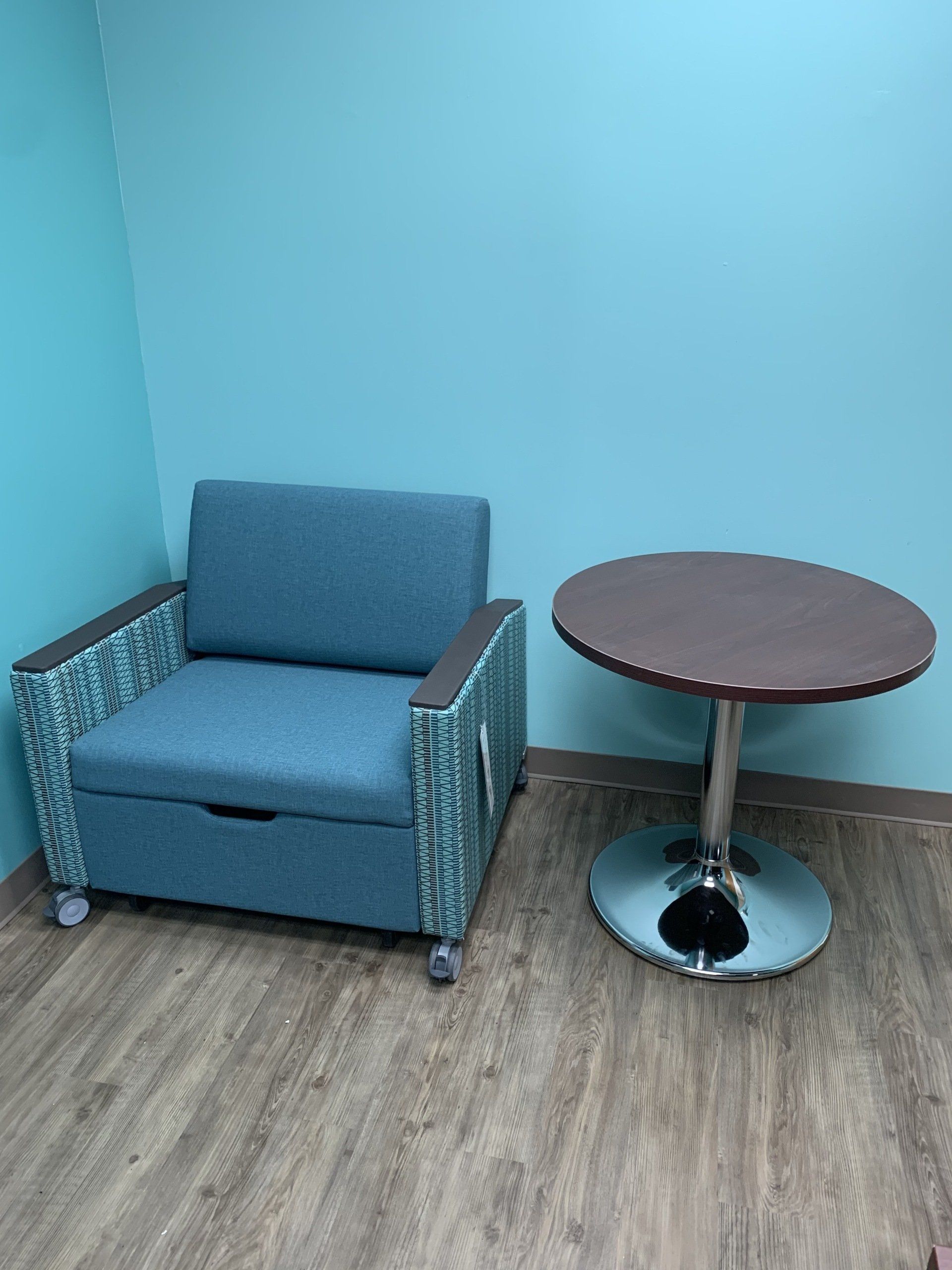 A chair and a table in a room with blue walls
