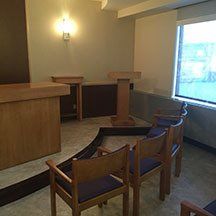 A room with a podium and chairs in it.