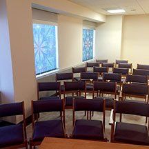 A room filled with rows of chairs and a table.