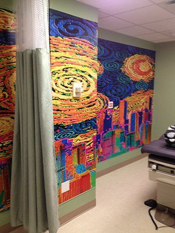 A doctor 's office with a colorful painting on the wall.