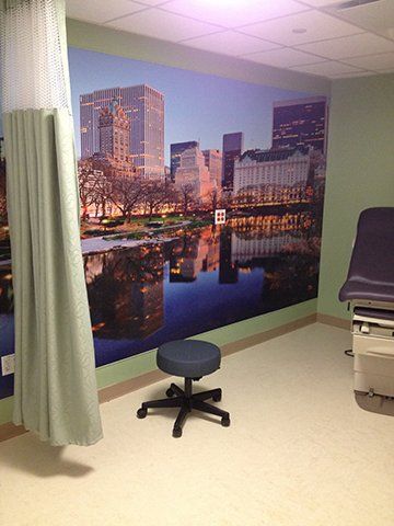 A doctor 's office with a large picture of a city on the wall.