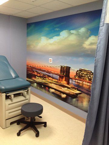 A doctor 's office with a picture of a bridge on the wall.