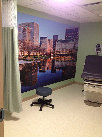 A doctor 's office with a large picture of a city on the wall.
