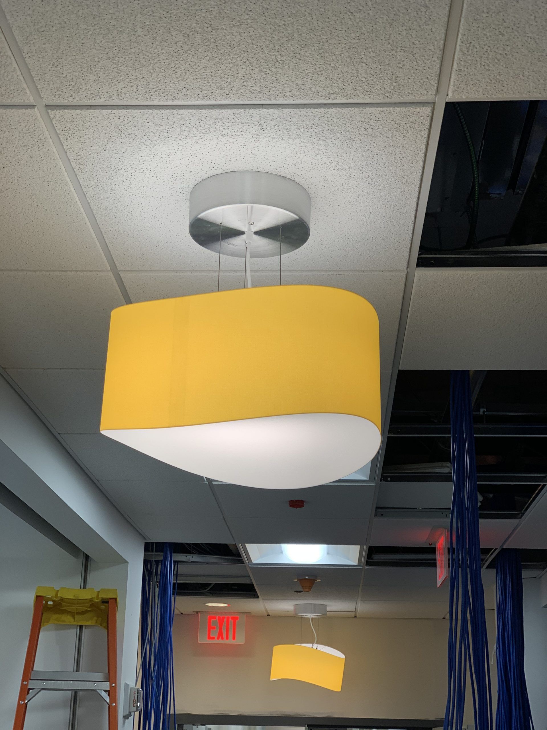 A ceiling with a yellow light hanging from it
