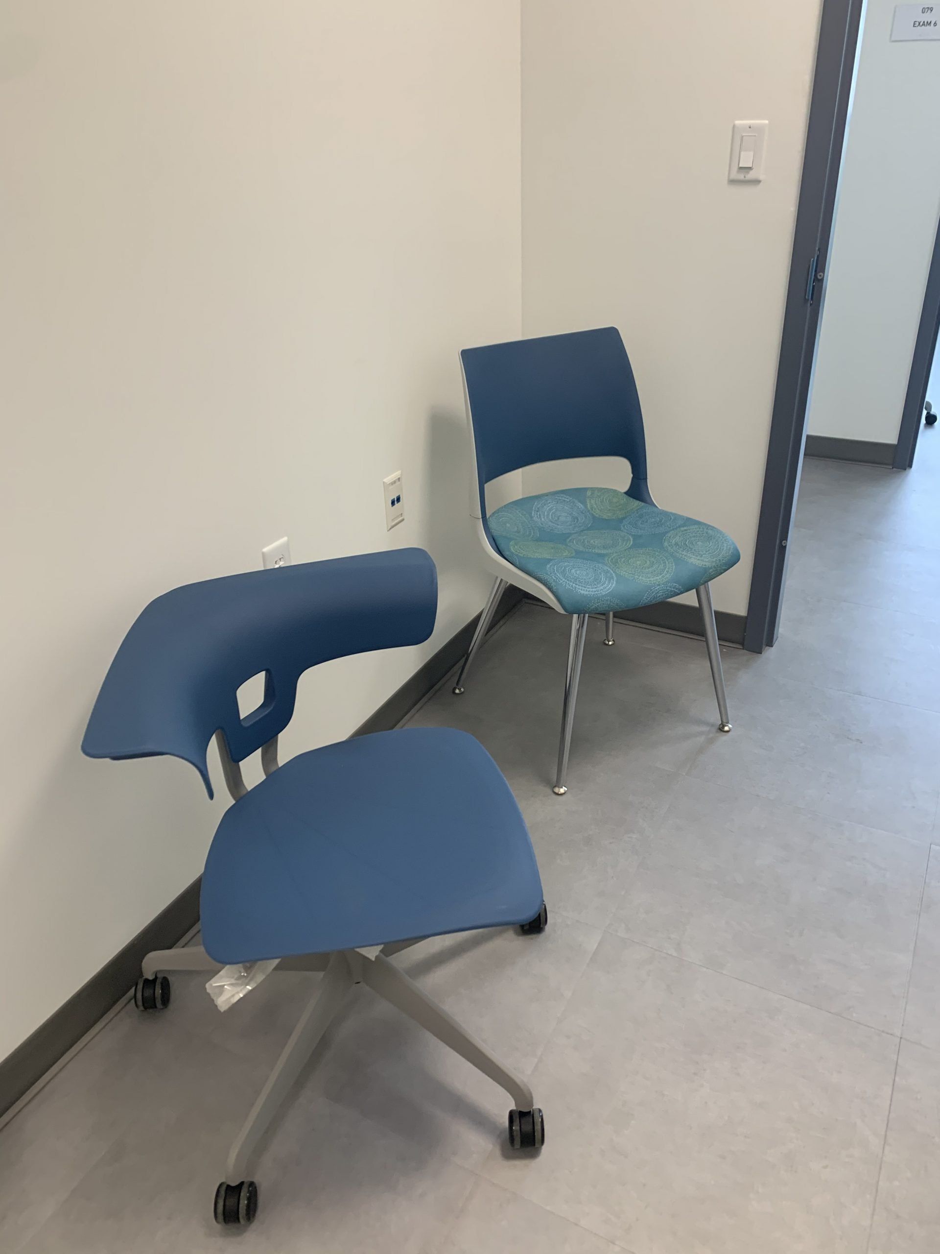 Two blue chairs are sitting next to each other in a room