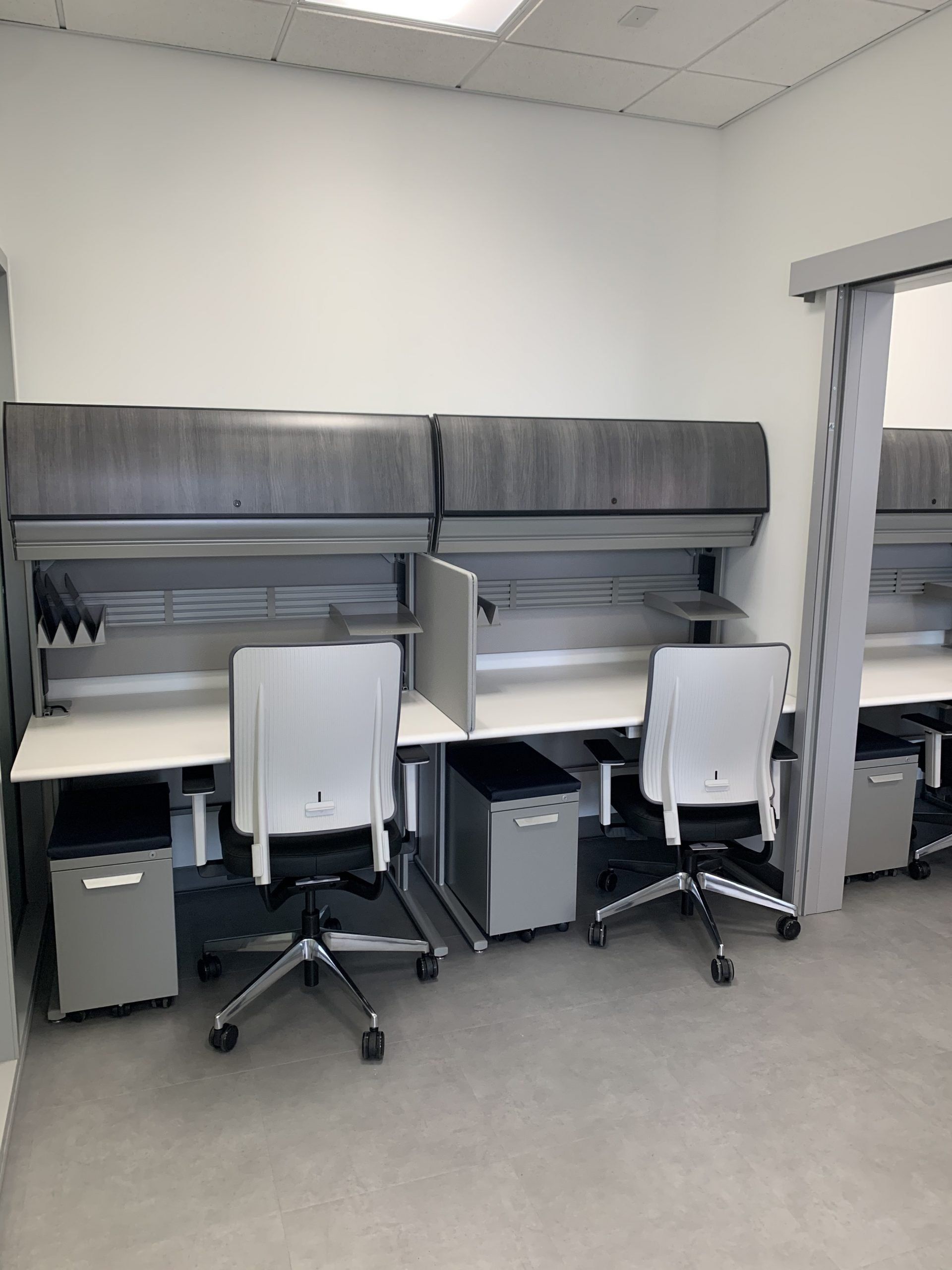 A room with three desks and chairs in it