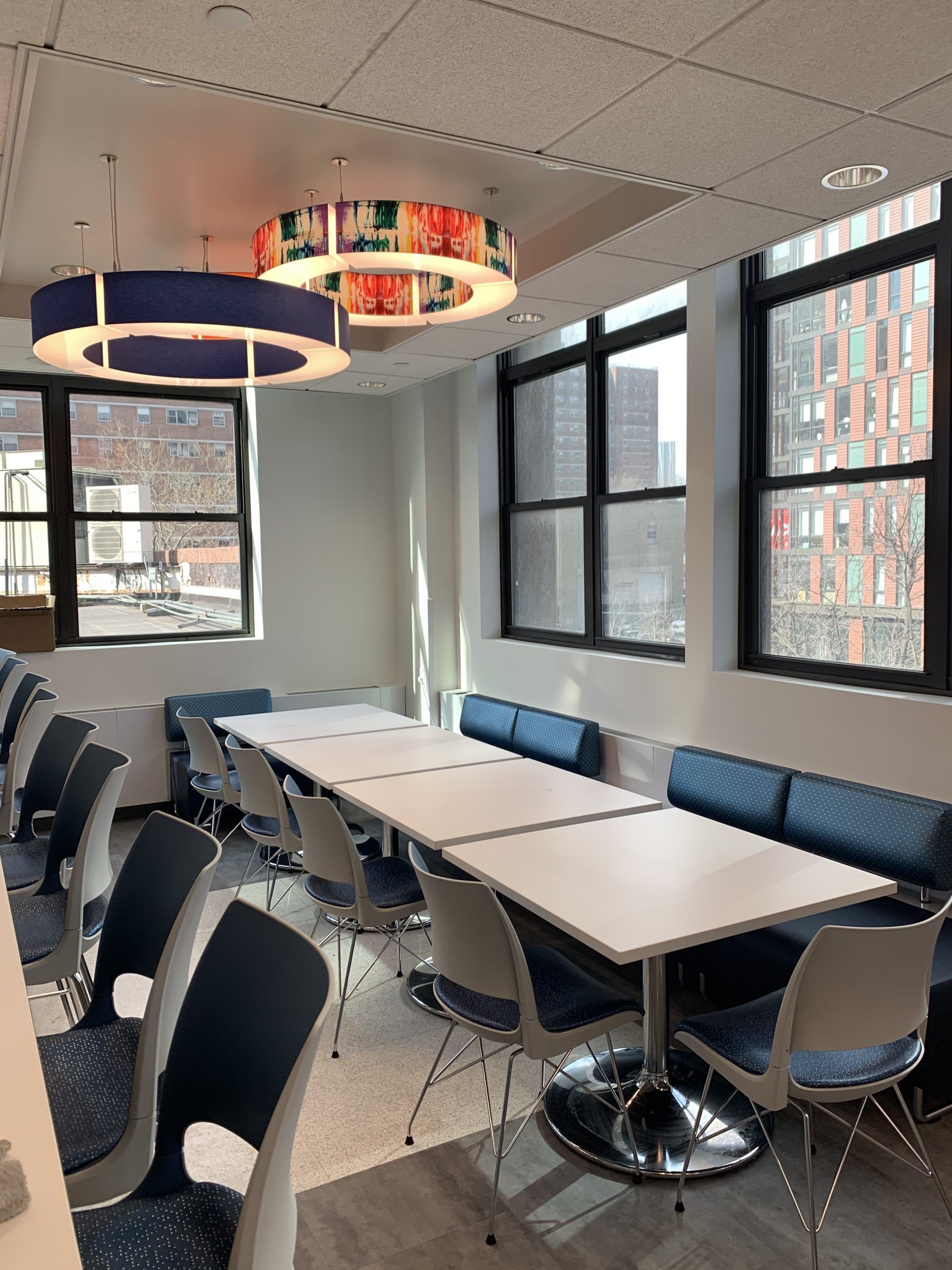 A room with tables and chairs and a ceiling light