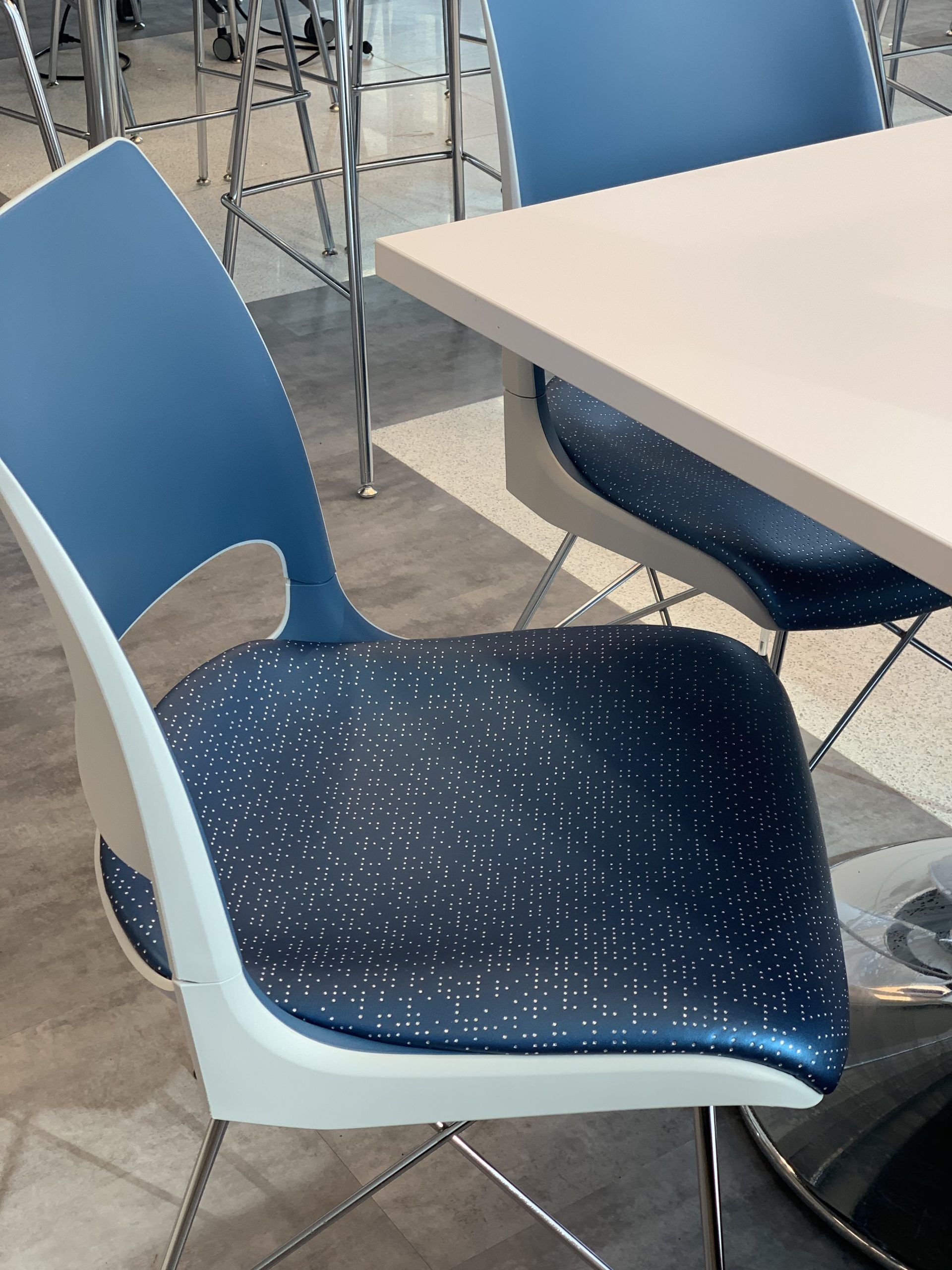 A blue and white chair sits in front of a table