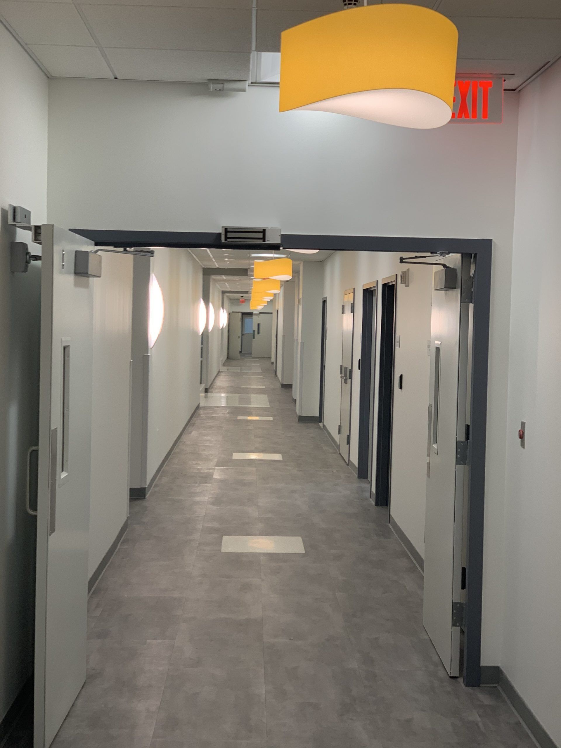A long hallway with a yellow light hanging from the ceiling