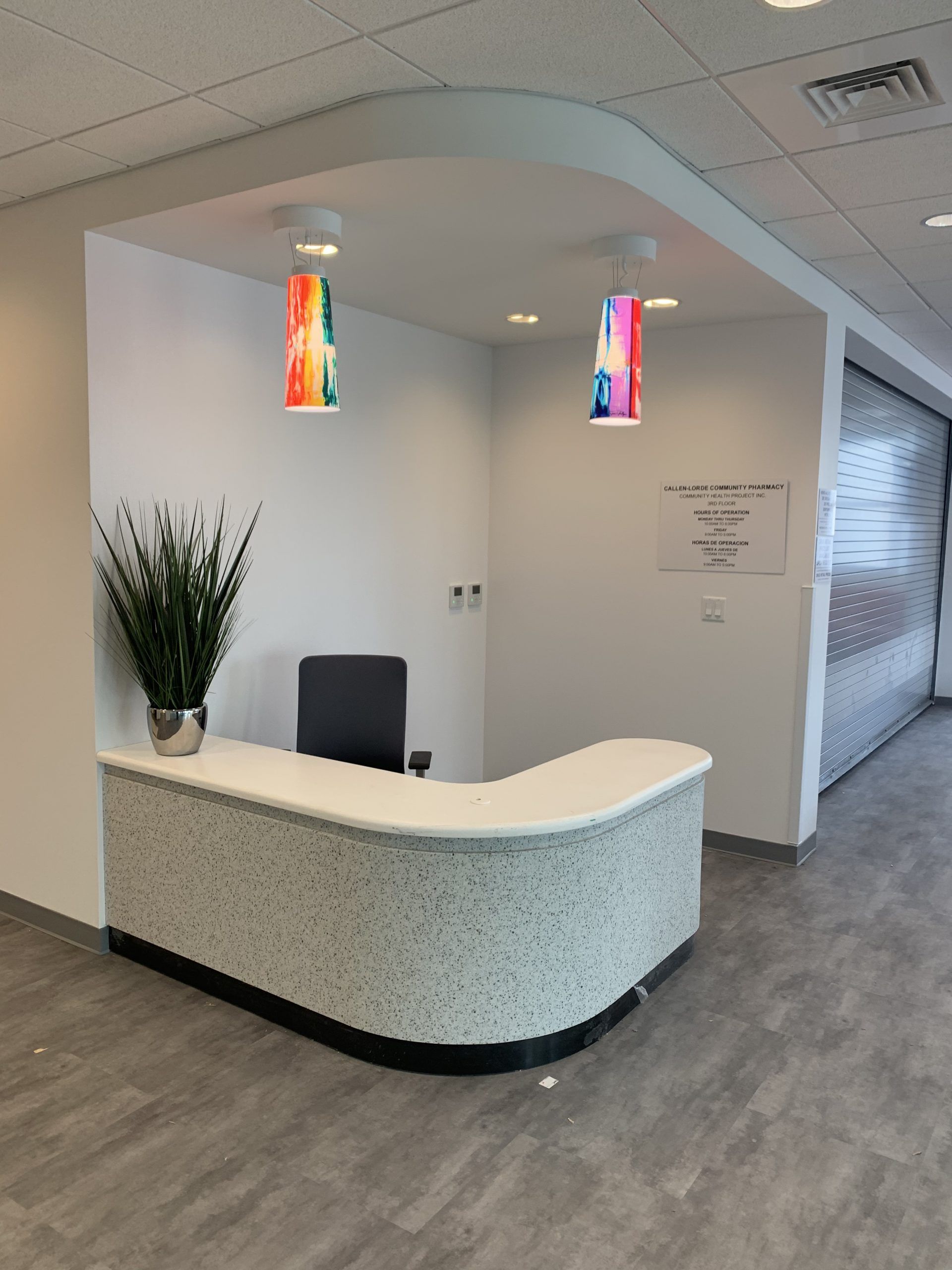A reception area with a white counter and a chair