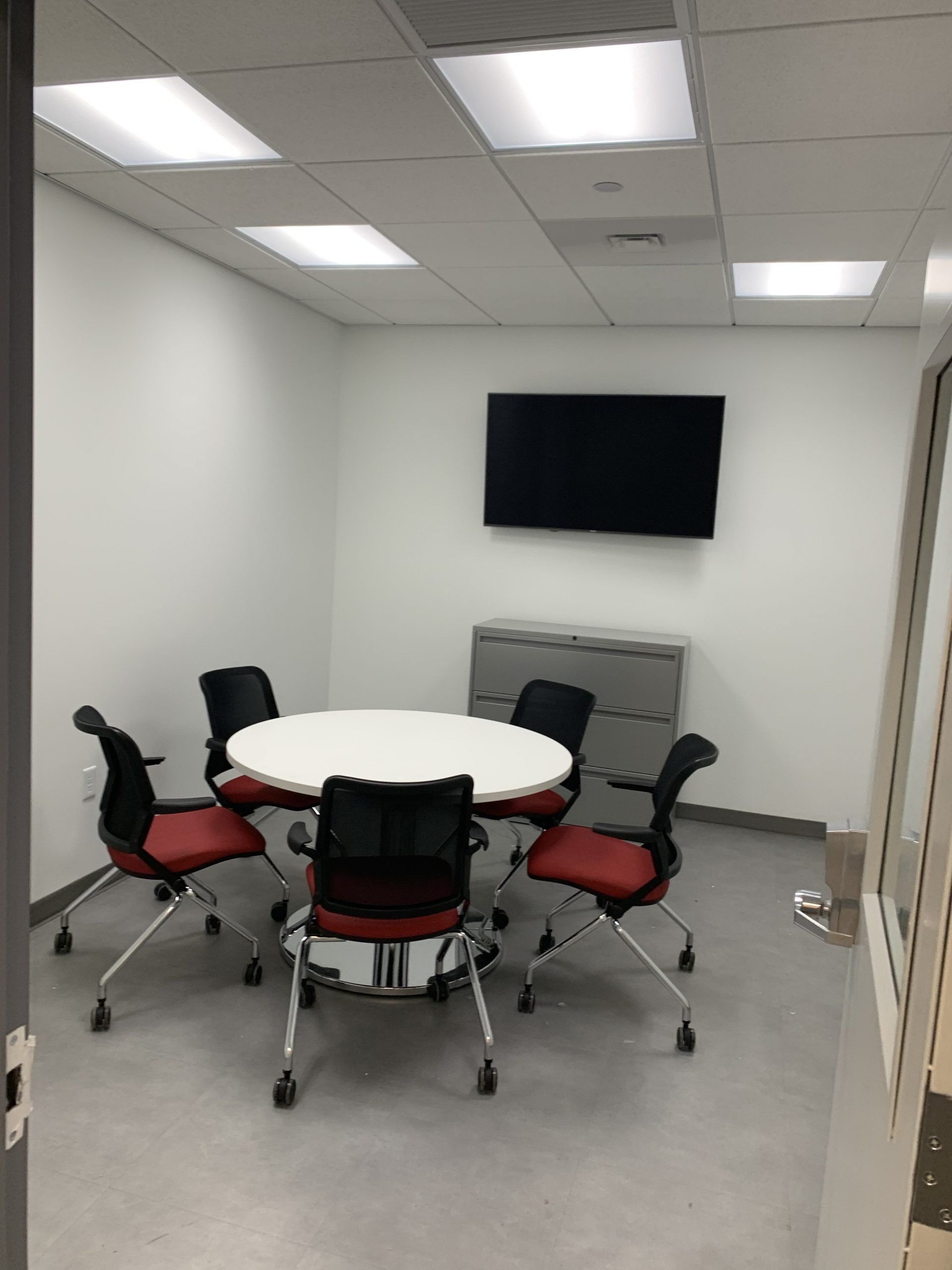 A conference room with a round table and chairs
