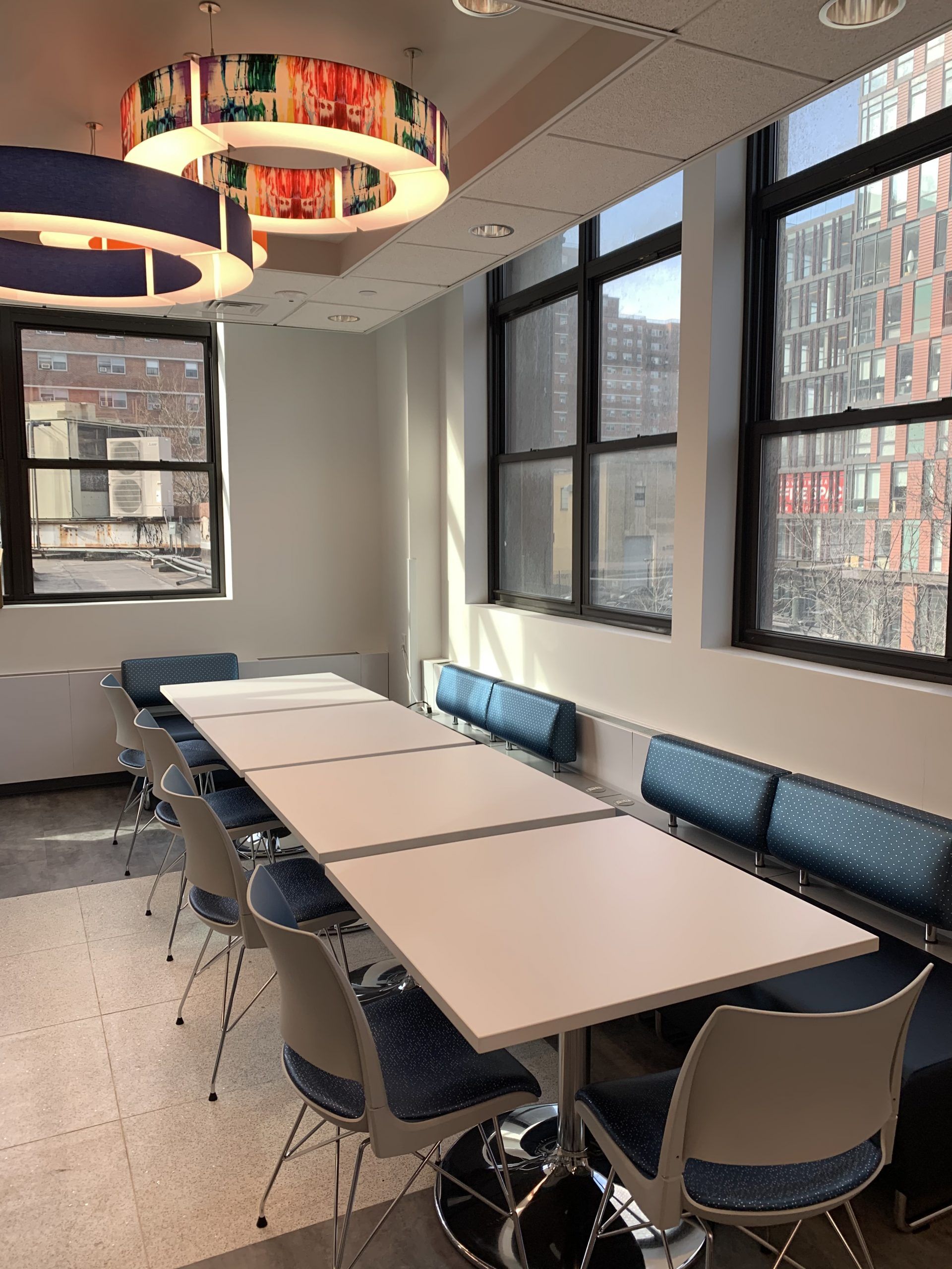 A room with tables and chairs and a lot of windows