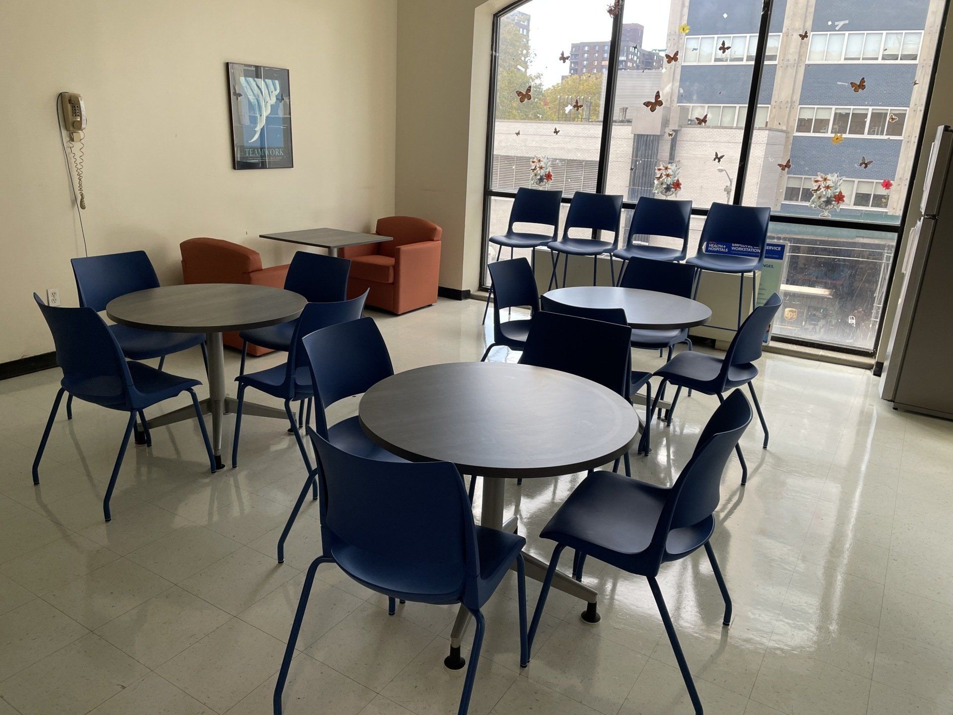 A room with tables and chairs in front of a window