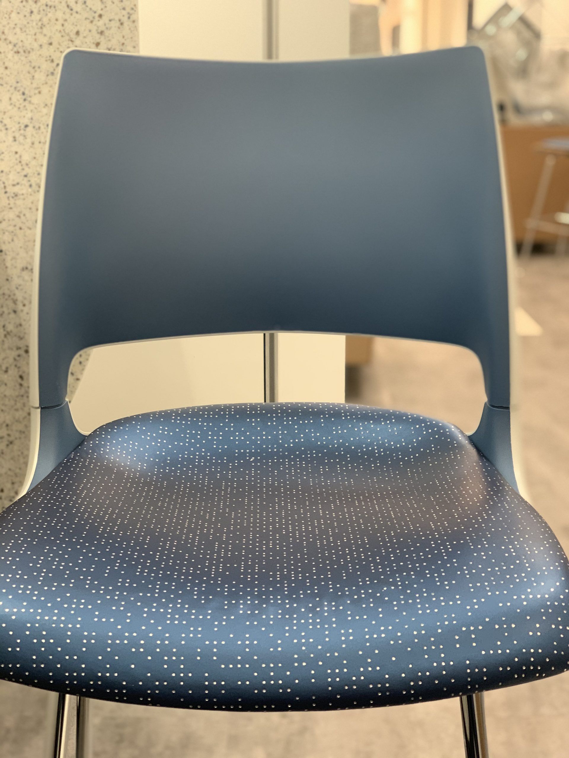 A blue chair with polka dots on the seat and back