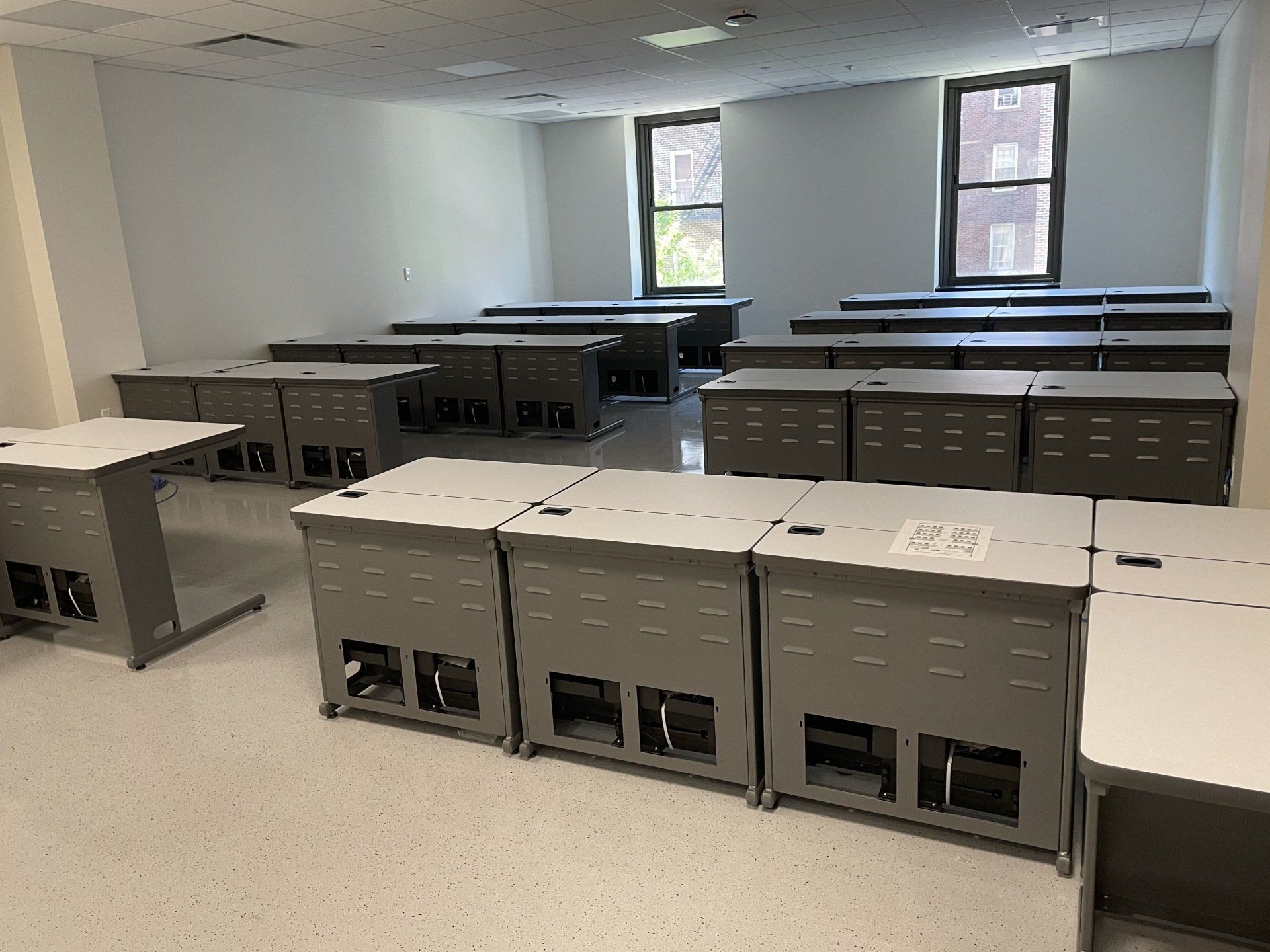 A classroom with rows of desks and a window.