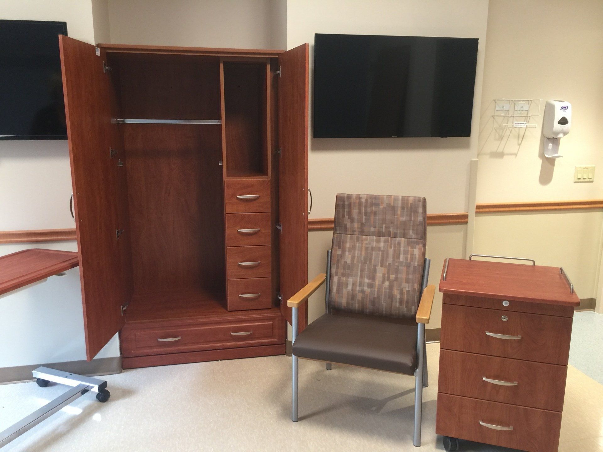 An empty room with a chair a dresser and a tv