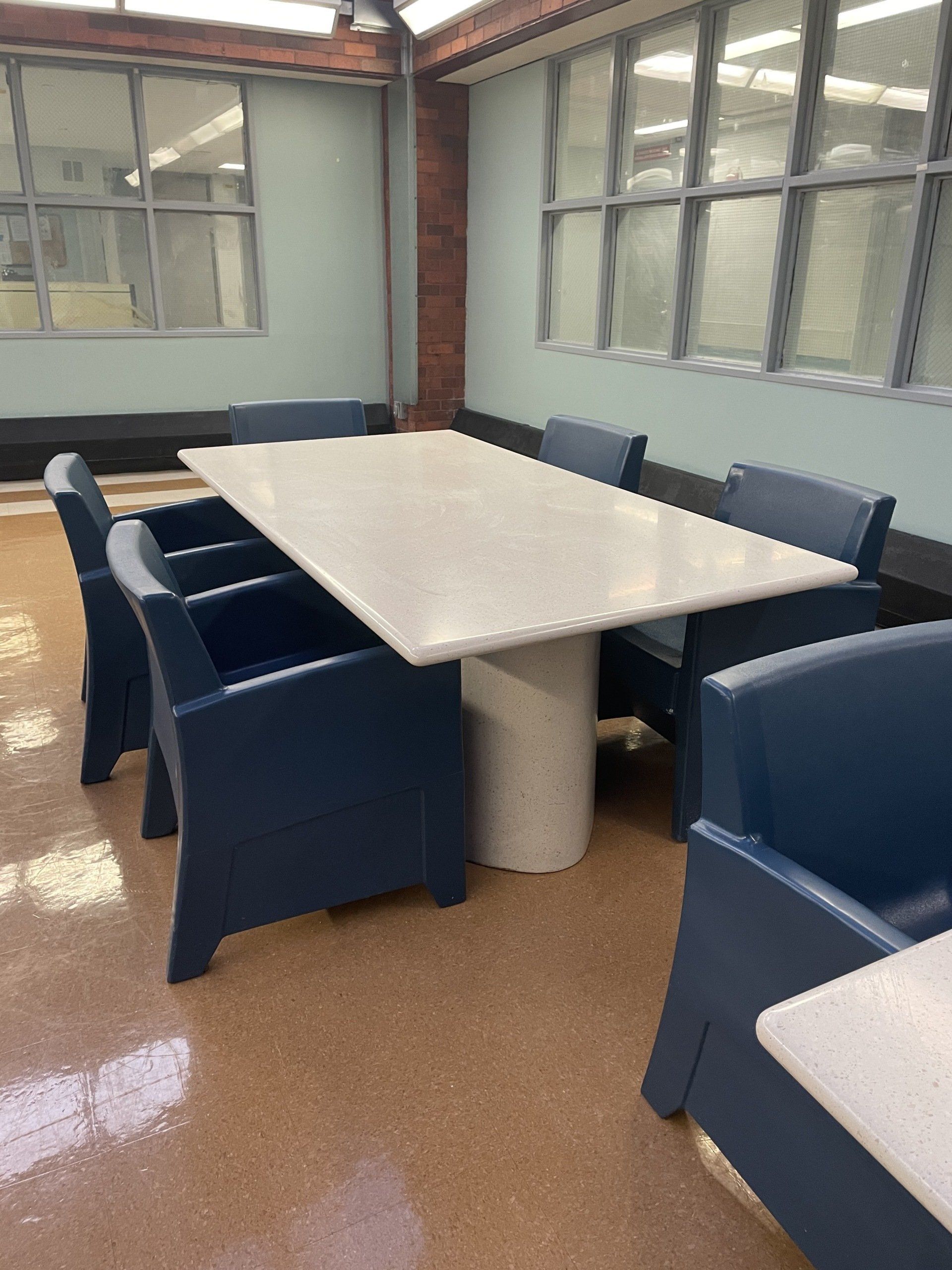 A conference room with blue chairs and a white table